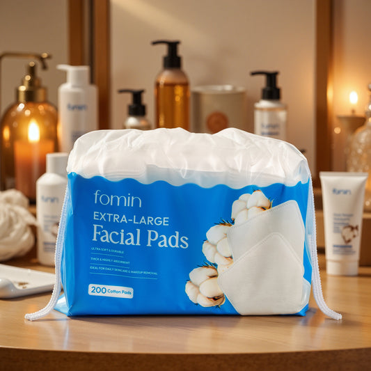 fomin Extra-Large Facial Pads packaging on a bathroom counter with various skincare products in the background.