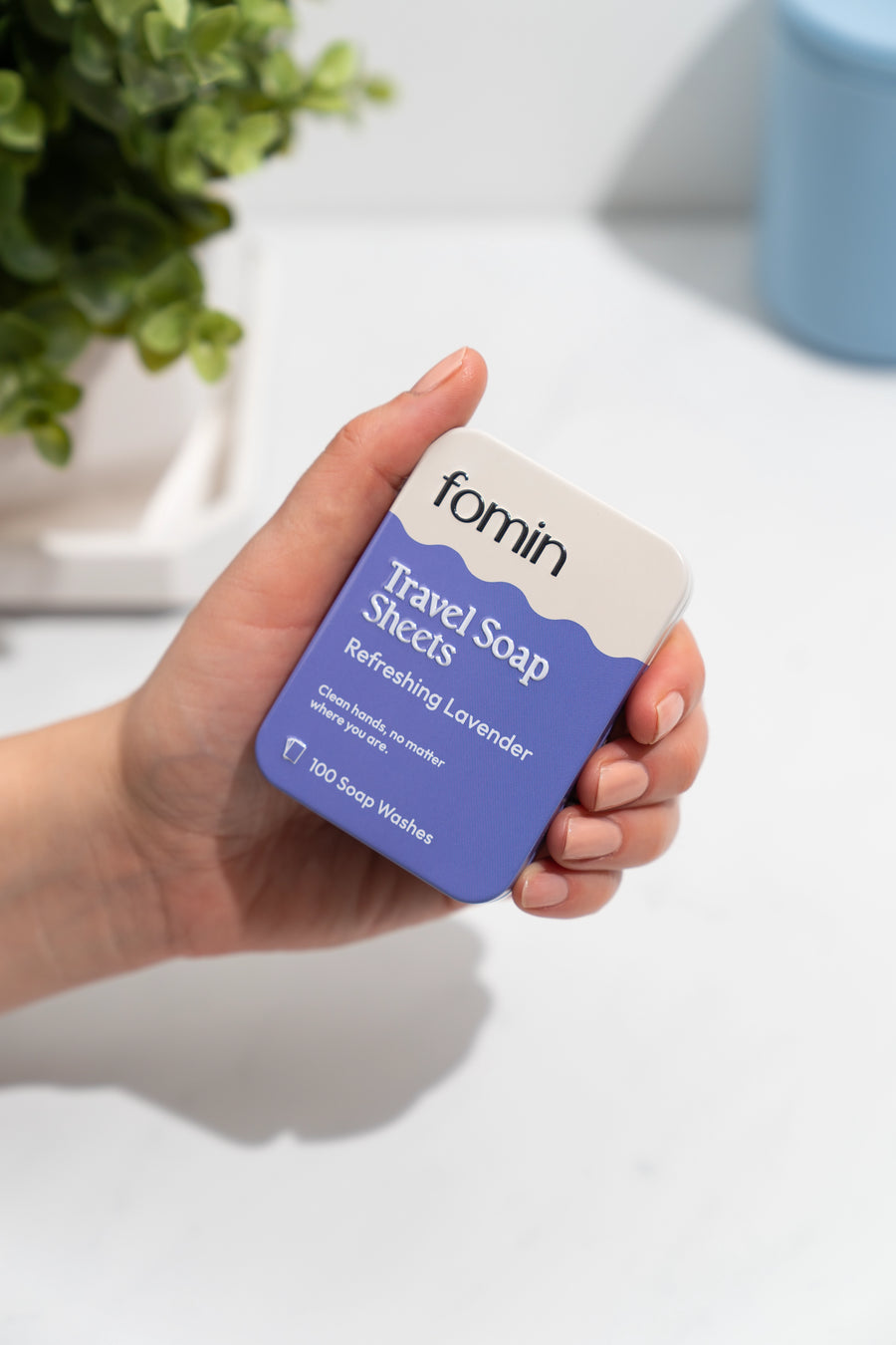 Hand holding a tin of Fomin Travel Soap Sheets